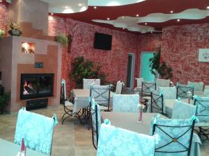 a dining room with tables and chairs and a fireplace at COMPLEX HARMONY/КОМПЛЕКС ХАРМОНИЯ in Tryavna