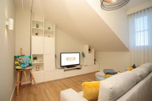 a living room with a couch and a tv at BESTVILLAS Collection Lilium in Braga