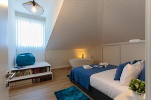a bedroom with a large bed with a blue blanket at BESTVILLAS Collection Lilium in Braga