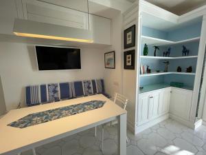 a dining room with a table and a tv at Le Rocce da Tragara, Tragara essential in Capri