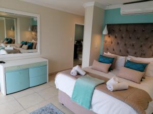 a bedroom with two beds and a large mirror at 307 Bermudas - by Stay in Umhlanga in Durban