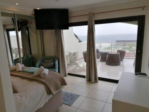 307 Bermudas - by Stay in Umhlanga في ديربان: غرفة نوم مع سرير وإطلالة على المحيط
