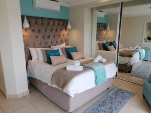 a bedroom with two beds and a large mirror at 307 Bermudas - by Stay in Umhlanga in Durban