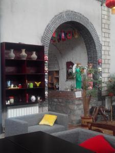 uma sala de estar com um sofá e uma lareira de tijolos em Jinan Mountain and Sea Culture Hotel em Jinan