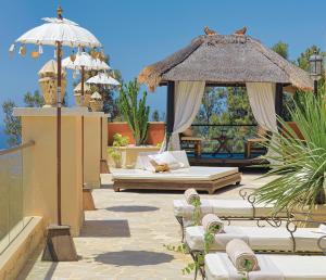 Royal Garden Villas, Luxury Hotel في أديخي: فناء مع شرفة وسرير