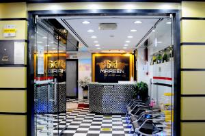 a store entrance with a checkered floor and chairs at Maaeen Hotel in Dubai