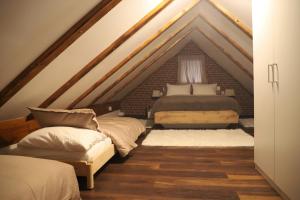 a attic bedroom with two beds and a couch at Kuća za odmor GUSKA in Kopačevo
