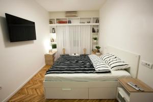 a bedroom with a bed with black and white pillows at Studio 10 in Belgrade +1 photo