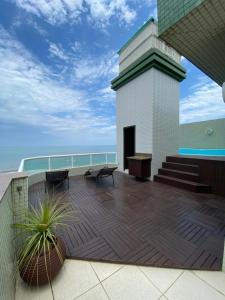a balcony with benches and a view of the ocean at Cobertura Beira Mar in Capão da Canoa