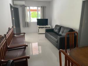 sala de estar con sofá y TV en Casa em Bombinhas, en Bombinhas