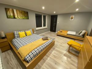 a bedroom with a bed with yellow pillows at Apartamenty Ogrodowa14 in Rymanów-Zdrój