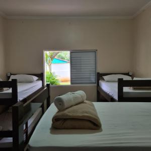 a bedroom with two beds and a window at Taipas Pousada e Camping in Iporanga