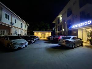 um parque de estacionamento com carros estacionados em frente a um edifício em Kangaroo Residence Udonthani em Udon Thani