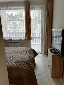 A bed or beds in a room at Borovets Gardens Apartment A27