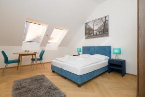 Vienna Stay Apartments Schönbrunn في فيينا: غرفة نوم بسرير وطاولة وكراسي