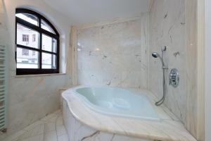 a white bathroom with a tub and a window at Vienna Stay Apartments Schönbrunn in Vienna