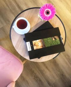 einen Glastisch mit einer Tasse Kaffee und einer Blume in der Unterkunft O&O Hotel Oberursel Zentrum in Oberursel