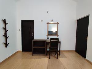 Habitación con escritorio, espejo y 2 puertas. en Bardia Forest Resort, en Bardiyā