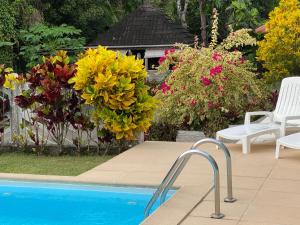uma piscina com um ramo de flores ao lado de uma casa em Villa Hausseman em Rivière-Pilote