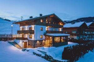 a large house in the snow in the winter at Serviced Luxury Chalet Evi, Ski-in Ski-out in Kaprun