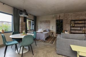 a living room with a bed and a table and a couch at De oude slaght- luxe suite met buitensauna in Zaandam