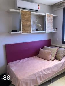 a bed in a room with a purple wall at Mandara Kauai - Apartamento 3 quartos Porto das dunas in Mangabeira +47 photos