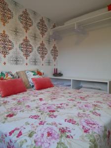 - une chambre avec un grand lit fleuri dans l'établissement Aconchegante Flat em condomínio na beira mar de Muro Alto - Malawi Beach Resort, à Porto de Galinhas