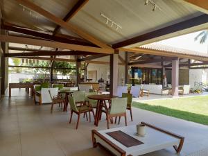 zewnętrzne patio ze stołami, krzesłami i blatem w obiekcie Aconchegante Flat em condomínio na beira mar de Muro Alto - Malawi Beach Resort w mieście Porto de Galinhas