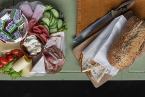 a tray of food with bread and cheese and vegetables at De oude slaght- luxe suite met buitensauna in Zaandam