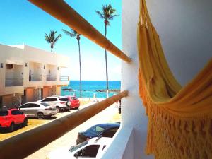 a hammock with a view of the ocean and palm trees at Casa Arembepe in Camaçari