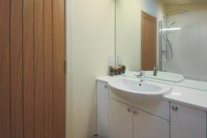 a white bathroom with a sink and a mirror at Balloch Park in Aberfeldy