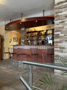 a restaurant with a bar with tables and chairs at Penzion T&T in Cheb