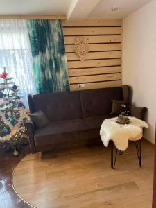 a living room with a couch and a christmas tree at Willa Omega in Zakopane