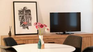 a table with a vase of flowers and a tv at Ferienwohnung Hahne in Goslar