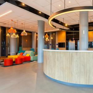 a lobby with a counter and colorful furniture at Tru By Hilton Criciúma in Criciúma