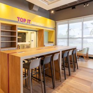 a bar with stools in a room with a top it breakfast sign at Tru By Hilton Criciúma in Criciúma