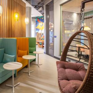 a seating area with chairs and tables in a store at Tru By Hilton Criciúma in Criciúma +17 photos