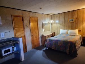 um quarto de hotel com uma cama e uma televisão em Red Ranch Inn em Catskill