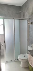 een badkamer met 2 glazen douchedeuren en een toilet bij Luz d'Sol - Residencial Familiar in Pombas