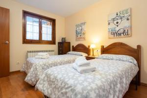 a bedroom with two beds with towels on them at Pie de pistas Fontcanaleta Lamolina in La Molina