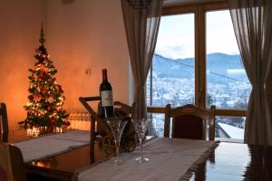 a table with a bottle of wine and a christmas tree at Apartment '84 in Pale