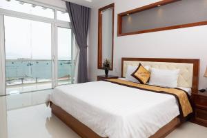 ein Schlafzimmer mit einem großen Bett und einem großen Fenster in der Unterkunft Sao Mai Hotel & Apartment in Vũng Tàu