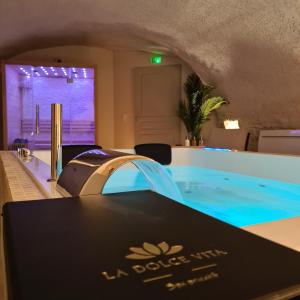 ein großer Pool in einem Zimmer mit einem Tisch in der Unterkunft La Dolce Vita Spa privatif in Dole