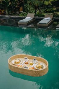 a tray of food in the water in a pool at Wana Karsa Ubud Hotel in Ubud