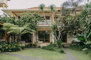 a house surrounded by trees and plants at Wana Karsa Ubud Hotel in Ubud
