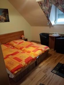 1 dormitorio con 1 cama con edredón amarillo y rojo en TÖRÖK VENDÉGHÁZ, en Sopron