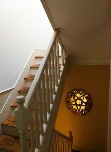 een trap met een witte rail en een kroonluchter bij The Big Bristol House in Bristol