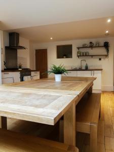een keuken met een houten tafel in een kamer bij The Big Bristol House in Bristol