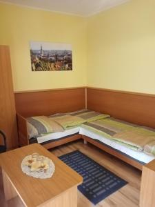 Habitación con 2 camas y mesa. en TÖRÖK VENDÉGHÁZ, en Sopron