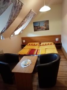 1 dormitorio con 2 camas, mesa y sillas en TÖRÖK VENDÉGHÁZ, en Sopron